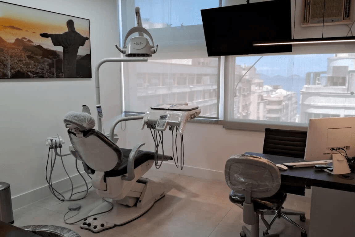 Cirurgião-dentista e paciente sorrindo no consultório
